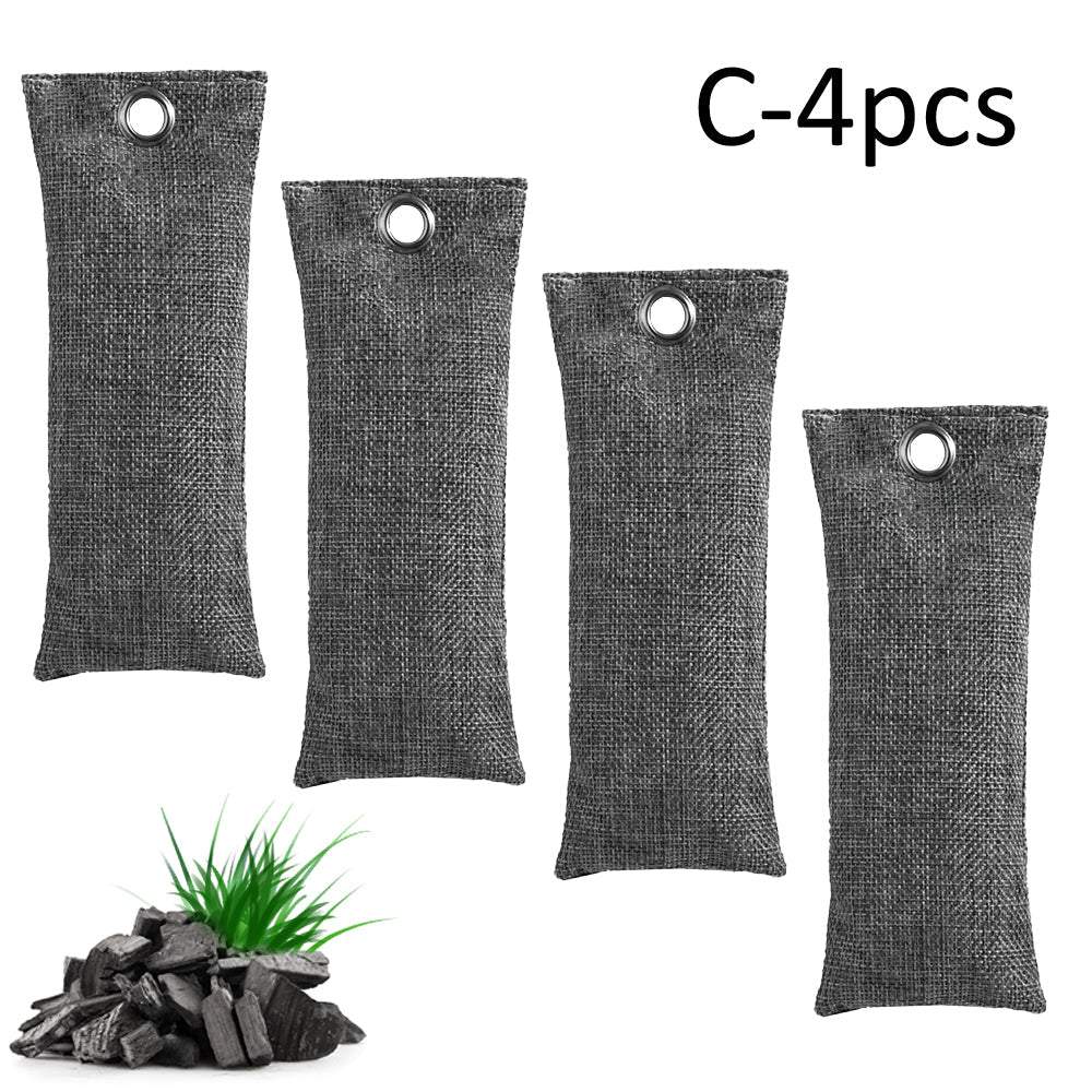 Four charcoal bags with a small pile of charcoal on a white background
